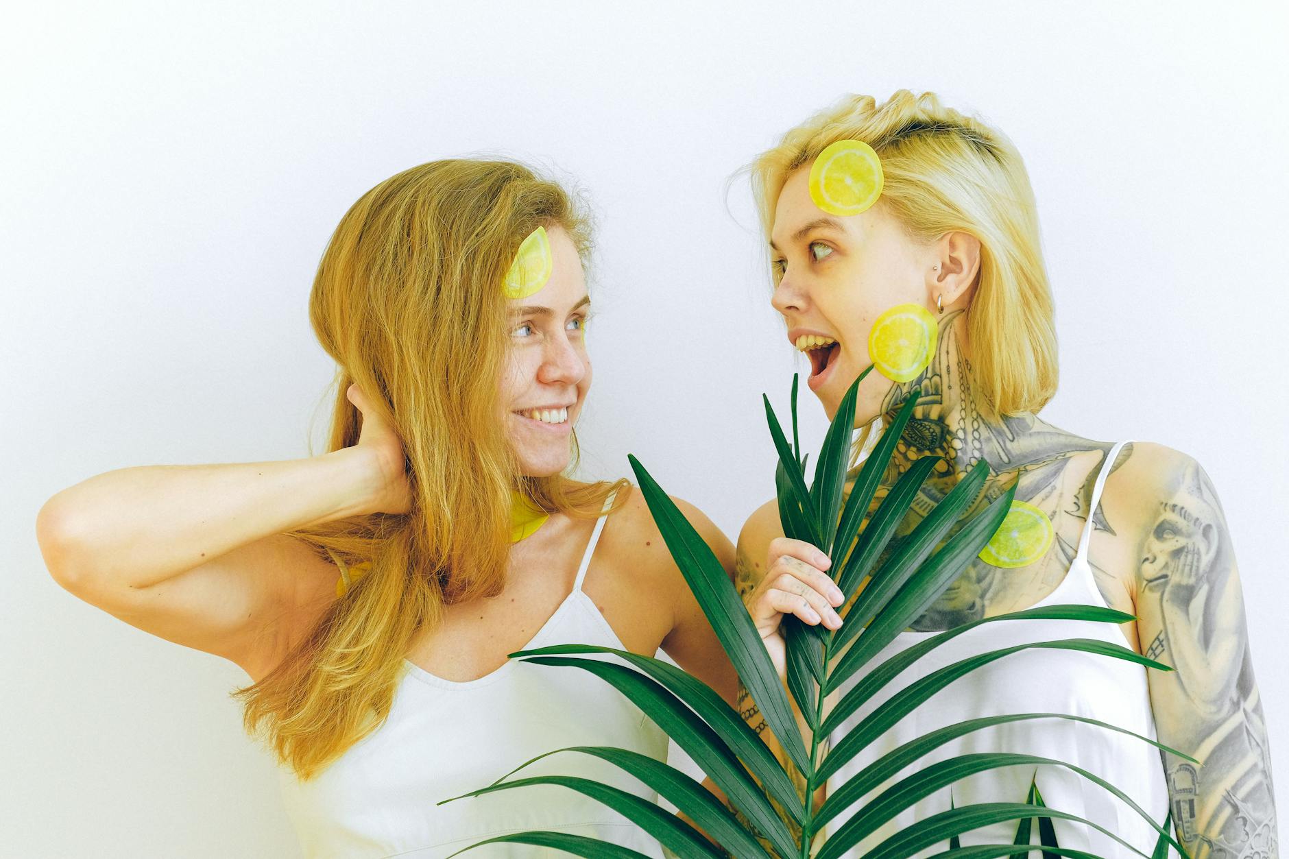 Two women smiling with lemon slices, expressing joy and confidence