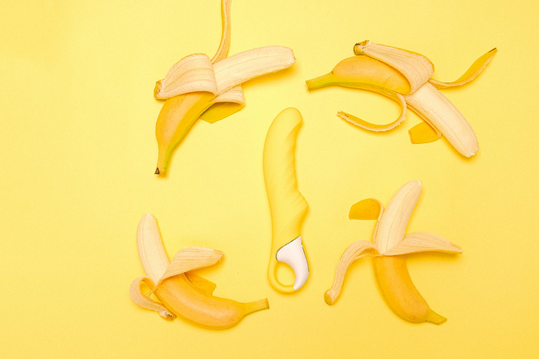 A bright yellow lemon clitoral vibrator on a cheerful yellow background