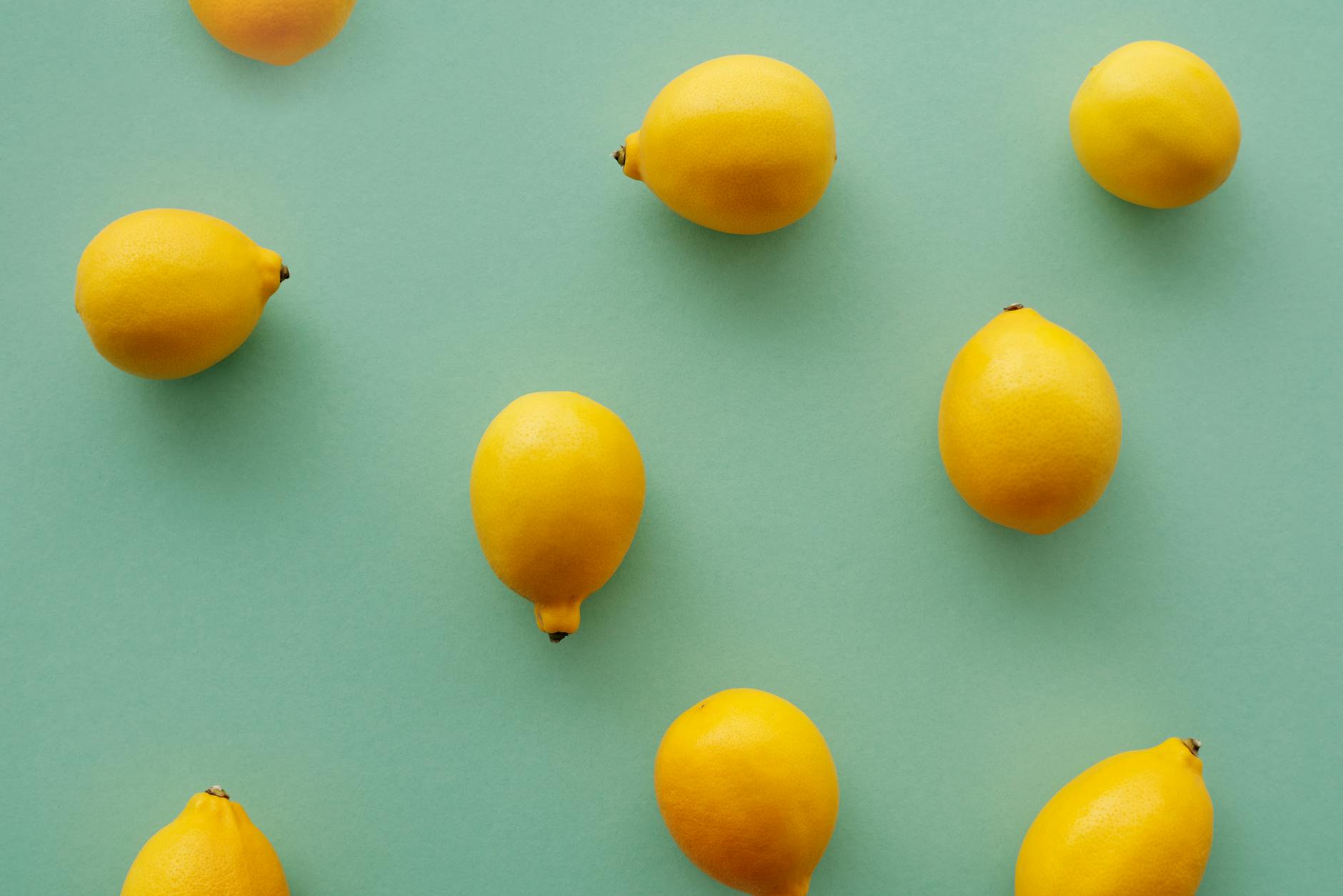 Bright yellow lemons arranged on a pastel green background, symbolizing fresh starts and renewal