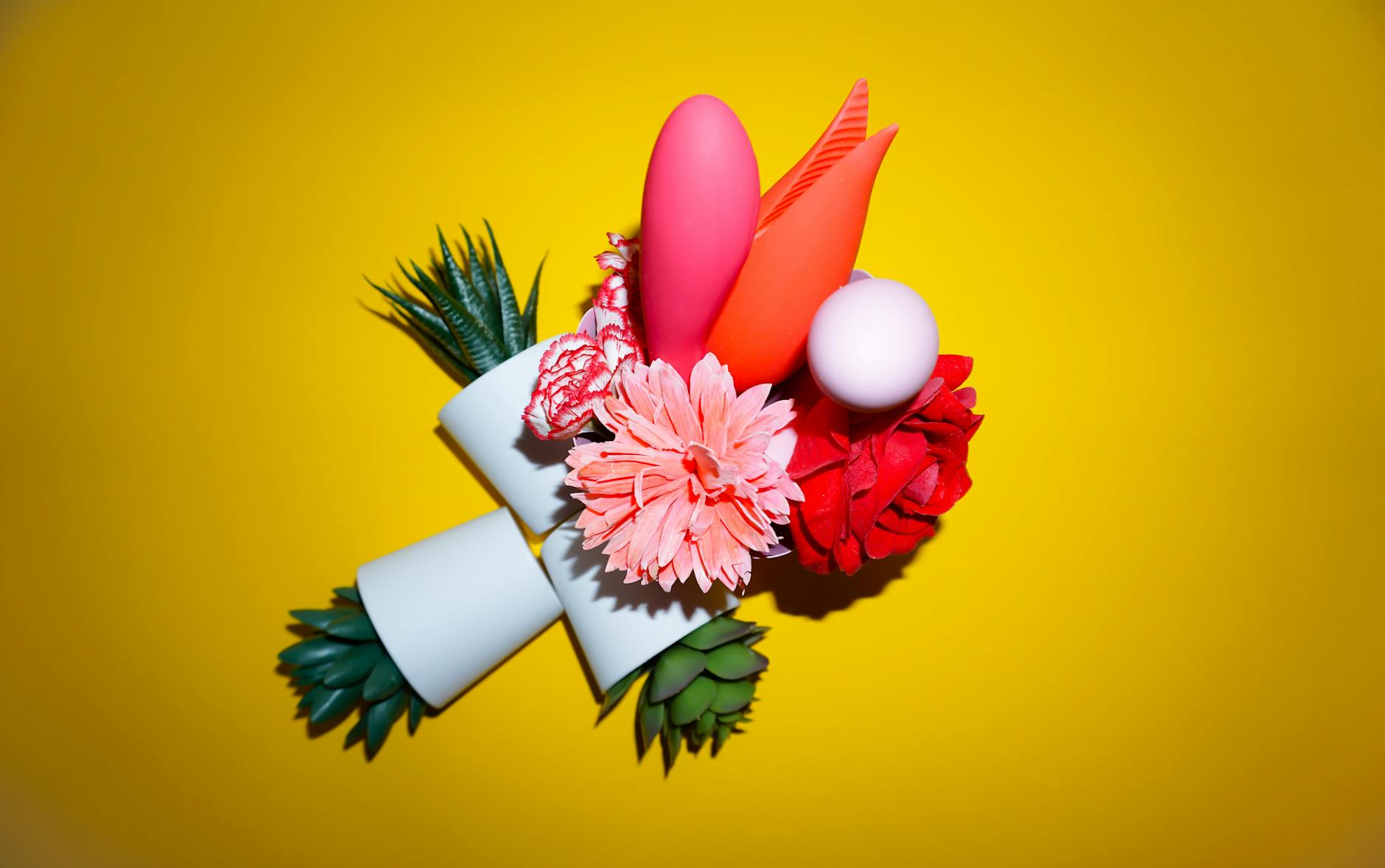 A person holding a basket containing colorful vibrators and a pink flower.